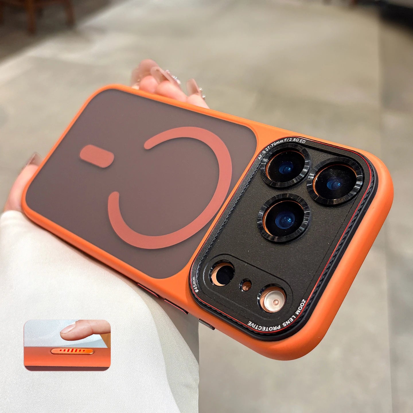 Orange phone case with a smiley face design held by a person